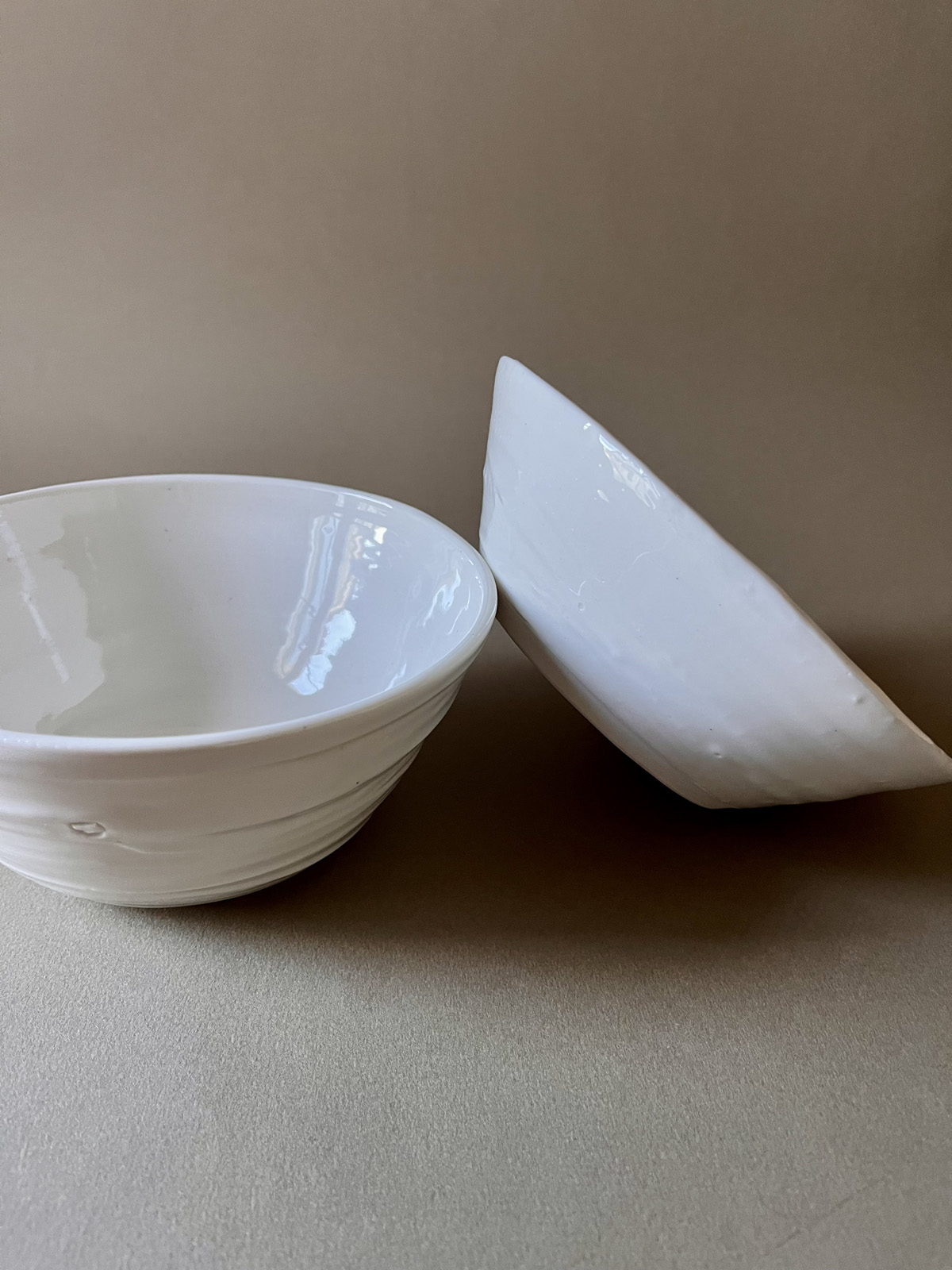 Deux bols Purete en porcelaine blanche, l'un en équilibre sur le bord de l'autre