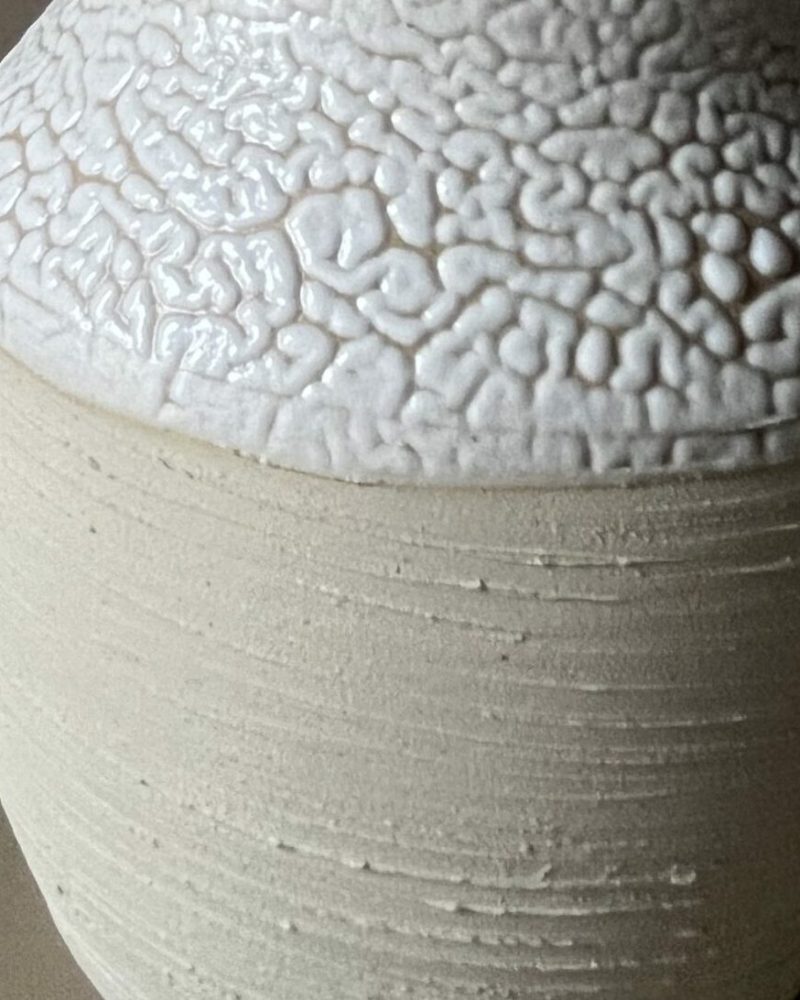 Vase Winter beige à col large avec graminée Vase Winter en grès beige strié à col large émaillé blanc rétracté, garni d'une graminée