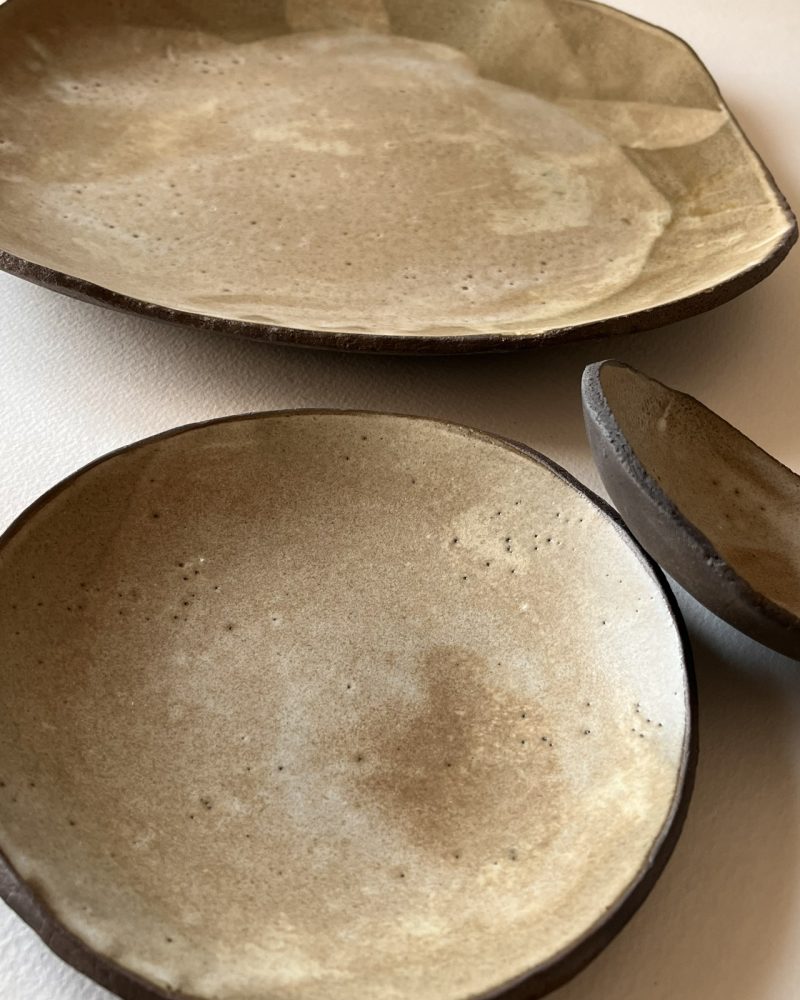 Assiettes brun et beige, formes libres Assiettes et coupelle en grès brun à l'émail beige nuageux, formes libres, vues de dessus