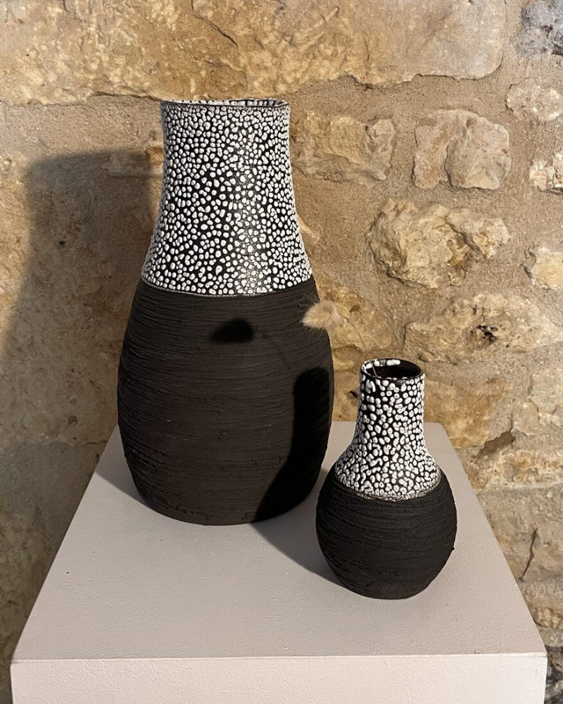 Deux vases Winter noirs sur socle Grand vase Winter à col évasé et petit vase Winter en grès noir strié, cols émaillés blanc, sur socle