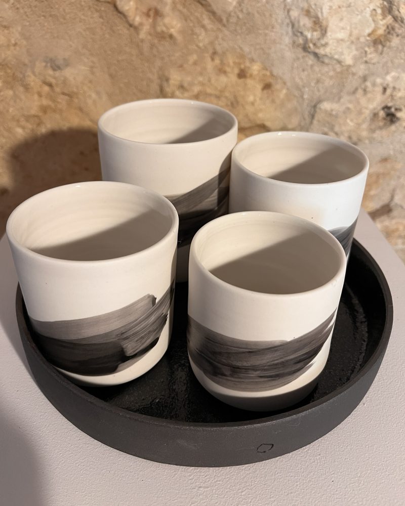 Quatre gobelets Hua en porcelaine au trait noir dans leur plateau noir, vue plongeante